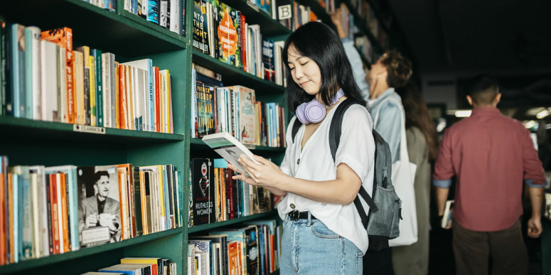 student reading book at bookshop