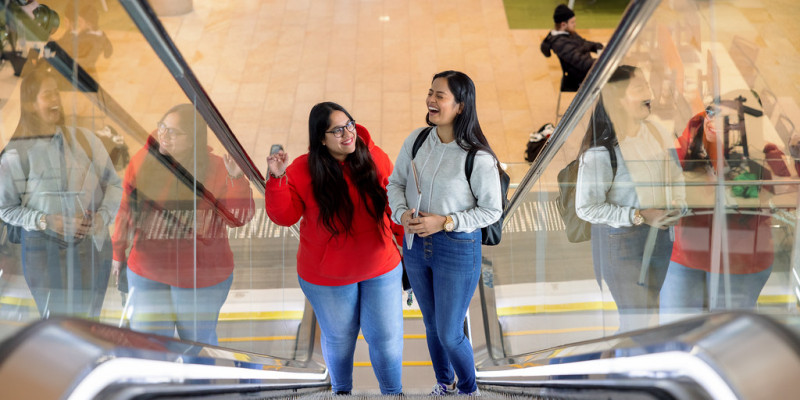 Students smiling on escalator